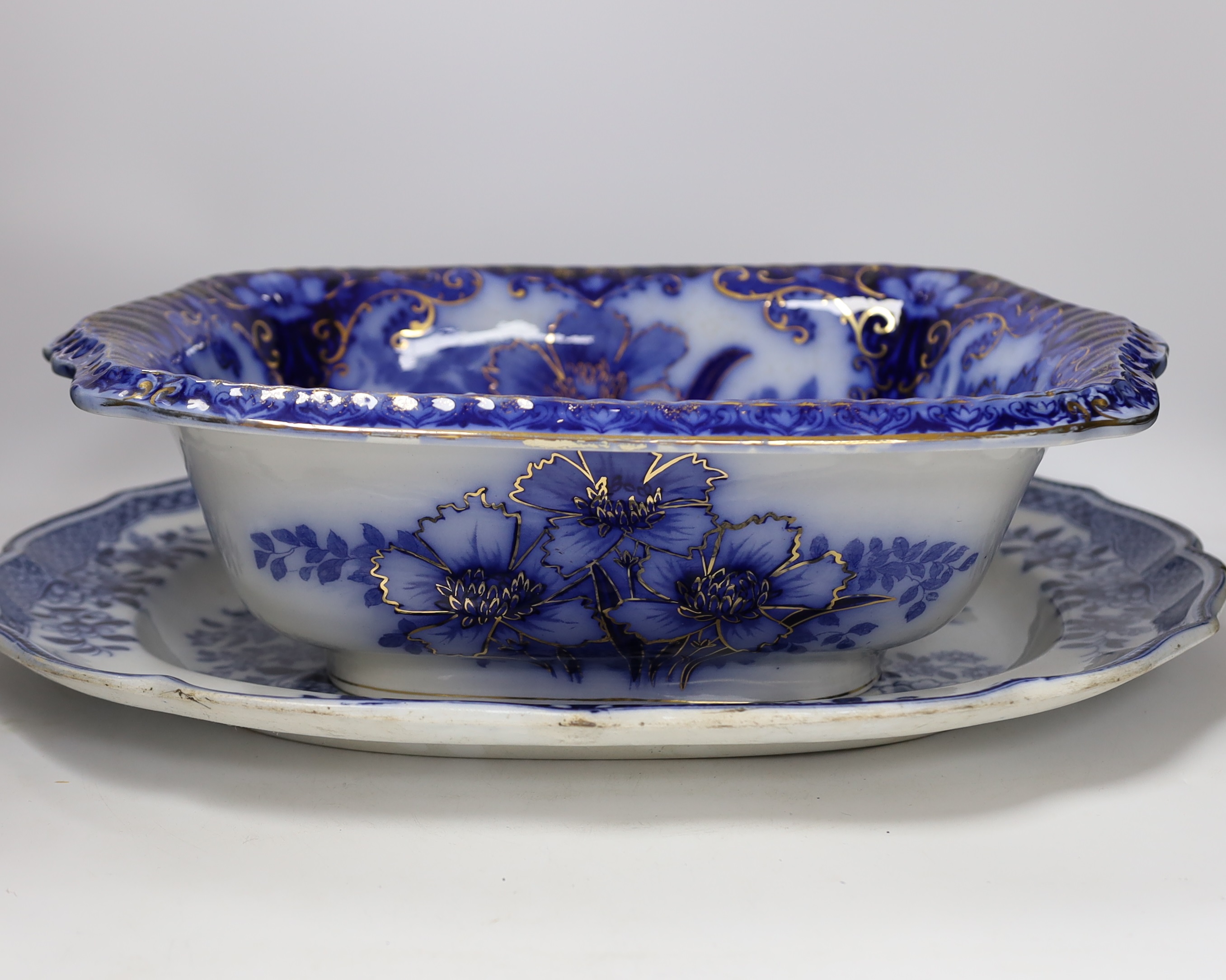 A Flow blue and gilt decorated bowl, a blue and white meat platter, a Royal Doulton vase, a gilt Egyptian inspired centrepiece and a set of six gilt bordered plates